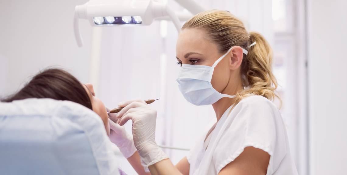 dentista examinando la boca de una paciente